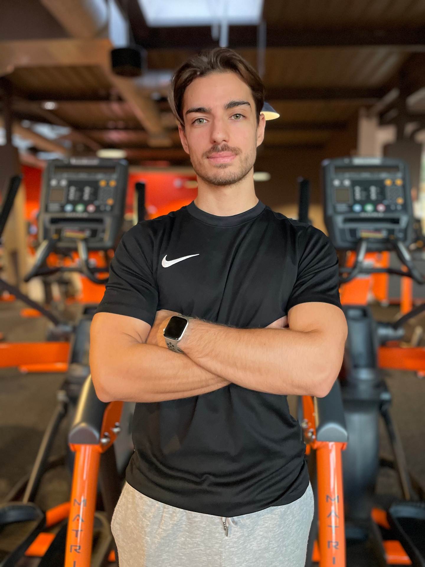 Jérémi Tour, coach sportif, bras croisés dans la salle de sport où il coache